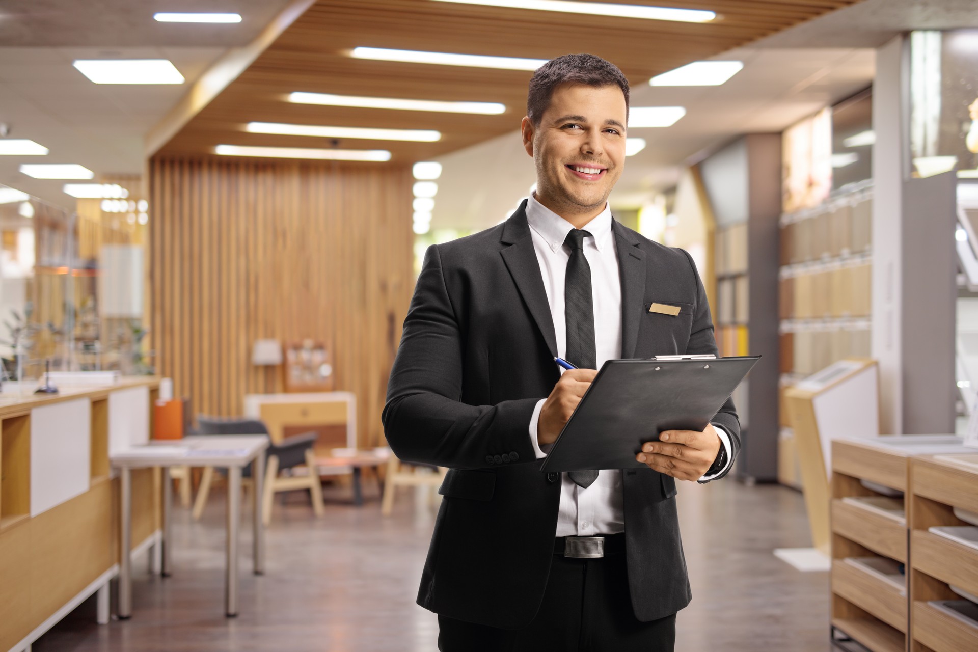 Receptionist in a hotel lobby holding a clipboard